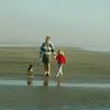 family walking on beach with dog