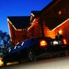 Stone cliff inn at night with limousine